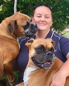 Asmiling woman with 2 boxer dogs.